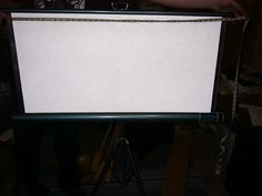 a person standing in front of a white board on a tripod with a black handle