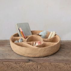 a wooden desk with a book and pencils in it, on top of a table