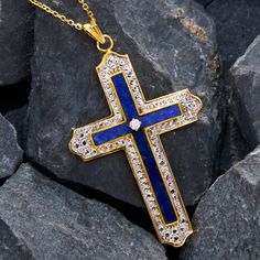 This superb cross pendant necklace is composed of four lapis tablets set into gold channels, with a round brilliant cut diamond in the center. Bordering the lapis is a white rhodium pattern that looks remarkably like diamonds. The cross is crafted in 14k yellow gold and measures 61.2mm long by 35.1mm wide. It hangs from a 14k yellow gold 18 inch cable chain with jump rings so it can also be worn at 16 and 17 inches long. Luxury Cross Necklace With Diamond Accents, Luxury Pendant Cross Necklace With Diamond Accents, Luxury Cross Pendant Necklace, Luxury Cross Necklace For Formal Occasions, Luxury Formal Cross Necklace, Luxury Cross Pendant Jewelry With Polished Finish, Luxury Cross Gemstone Jewelry, Luxury Gemstone Cross Jewelry, Luxury Cross-shaped Gemstone Jewelry