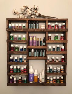 a wooden shelf filled with lots of different types of medicine bottles and flowers on top of it