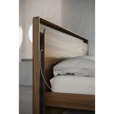 a wooden bed frame with white sheets and pillows