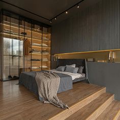 a large bed sitting on top of a wooden floor next to a wall filled with shelves