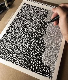 a person is drawing on a piece of paper