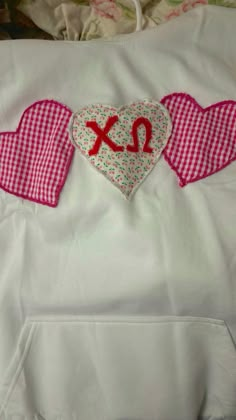 two heart shaped appliques are on the back of a pillow