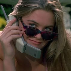 a woman wearing sunglasses talking on a cell phone