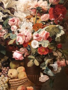 a vase filled with lots of flowers and fruit