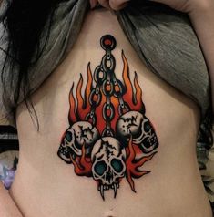 a woman's stomach with skulls and flames on it