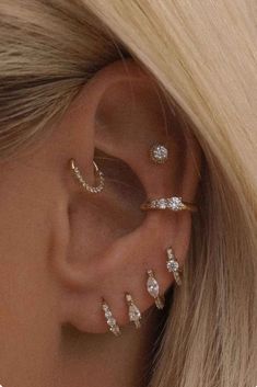 a woman with blonde hair wearing three ear piercings