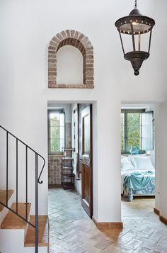 an entry way with a brick wall and stone steps leading up to the bedroom in the background