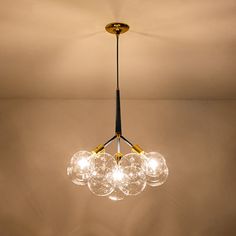 a chandelier with five glass balls hanging from it's center and four lights on each side