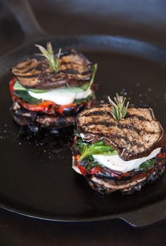 two grilled sandwiches sitting on top of a black plate with the words bonn appeti