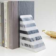 a bookend made out of marble blocks with a gold bird figurine next to it