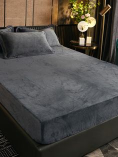 a bed with a gray comforter and pillows