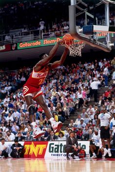 a basketball player dunking the ball in front of an audience