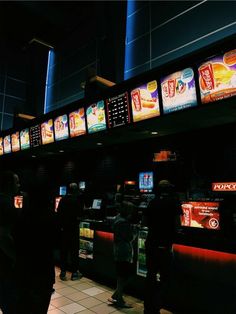 people standing in line at a fast food restaurant with menus on the wall behind them