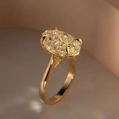 a yellow diamond ring sitting on top of a table