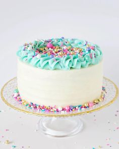 a white cake with sprinkles and blue frosting