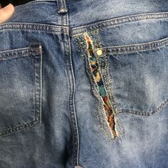 someone is showing off their jeans that have been decorated with colorful beads and sequins