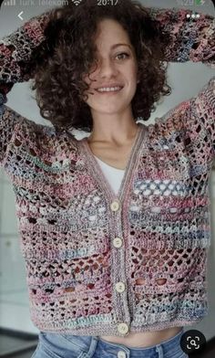 a woman with curly hair wearing a cardigan