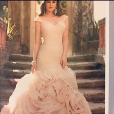 a woman in a wedding dress standing next to stairs