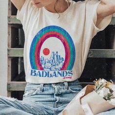 Welcome to the Badlands. Inspired by vintage southwest. Boyfriend fit tee, available in Soft Cream or Oatmeal Triblend. badlands arizona phoenix desert southwest soft cream triblend tee tshirt souvenir vintage shirt Womens Graphic Tees Vintage, Rainbow Tshirt, Vintage Style 70s, Arizona Gifts, 70s T Shirts, Womens Graphic Tees, Western Graphic Tees, Graphic Tees Vintage, New Energy