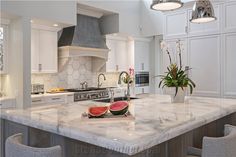 a large kitchen island with watermelon slices on it's countertop and chairs