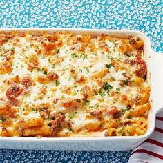 a casserole dish with meat and cheese in it on a blue tablecloth