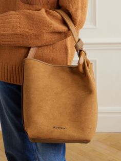 JW Anderson's latest 'JWA Corner' bag is made from soft brown canvas, which enhances the slouchy shape and relaxed look. It's topped with a matching suede handle, knotted around the designer's iconic oversized chain link, and has plenty of room inside for your phone, purse and makeup compact. Hobo Shoulder Bag With Suede Lining, Everyday Hobo Bag With Suede Lining, Brown Work Bag With Dust Bag Included, Brown Hobo Bag With Suede Lining For Shopping, Chic Brown Bag With Suede Lining, Brown Bag With Suede Lining, Chic Brown Shoulder Bag With Suede Lining, Brown Suede Shoulder Bag For Work, The Row Bag