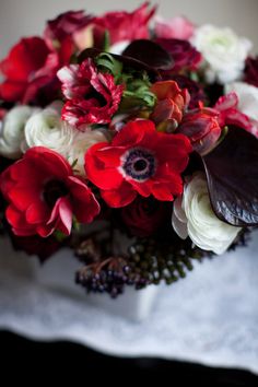 red and white flowers are arranged in a bouquet