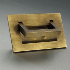 a square metal object on a gray surface