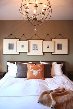 a bed with pillows and pictures hanging on the wall