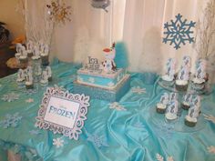 a table topped with cupcakes and cakes covered in frosted snowflakes