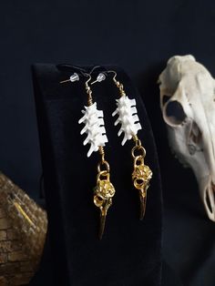 Here are some Beautiful Golden Raven Skull earrings! Each Pair is Made with 8 Real Rattlesnake Vertebrae, The Hooks Are Gold Stainless Steel. These Earrings are Around 4 Inches Long. All Items Ship Within 1-3 Days via USPS First Class Service,  With Some Upgrades Available Also. Shipping on These Will be 5.00 Additional Items are Free! International Shipping Will Be 20.00, And All Additional Items Are FREE! International Shipping May Take 2 - 6 Weeks To Deliver. I Always Love to Accommodate Custom Orders! If you Have Something in Mind , Please Message me. Have a Drawing or a Photo of Your Inspiration and Send it to Me! And Also Please Send Me Your Preferred Budget For Your Piece, To Make Sure You are Not Overcharged. I DO NOT Carry Human Bones or Any Sort Of Illegal Items. And As Etsy Sell Wiccan Earrings, Earrings Goth, Earrings Bird, Forest Core, Earrings Gothic, Goth Earrings, Human Bones, Bone Earrings, Raven Skull