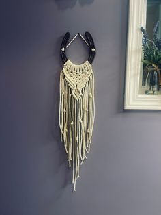 a white and black wall hanging next to a mirror