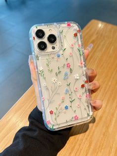 a woman holding up her phone case with flowers on the front and back cover in clear