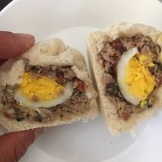 a person holding an egg in a pita bread with meat and cheese on it