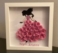 a pink dress made out of paper roses in a white frame with the words nagah arranine on it