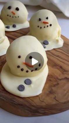 four snowmen on a wooden board with buttons