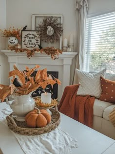 a living room filled with furniture and a fire place covered in pumpkins on top of a table