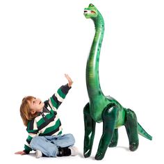 a young boy playing with an inflatable dinosaur