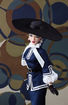 a doll wearing a black hat and blue dress