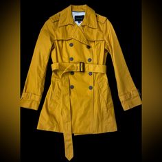 Light And Classic Trench Coat By Banana Republic Mustard Yellow Coat With Dark Brown Buttons Shell: 100% Cotton Lining: 100% Polyester Pit To Pit : Approx 17 Inches Length : Approx 30 Inches Lined Interior Removable Belt Double Breasted With Buttons Front Pockets Back Vent Cuffs With Belts In Excellent Condition. Never Worn But Tags Taken Off. Fitted Mustard Outerwear For Work, Trendy Yellow Outerwear For Work, Classic Yellow Long Sleeve Outerwear, Chic Mustard Outerwear For Work, Classic Fitted Yellow Outerwear, Classic Yellow Outerwear For Winter, Trendy Mustard Outerwear For Spring, Mustard Fitted Fall Outerwear, Yellow Fall Outerwear For Work