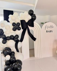 black and white balloons are on display in front of a baby's name sign