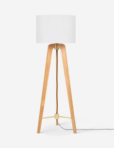 a wooden tripod floor lamp with a white shade