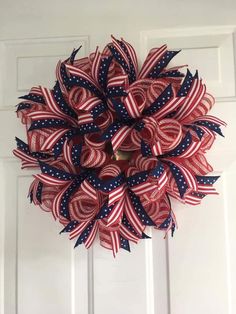 a red, white and blue wreath hanging on the front door