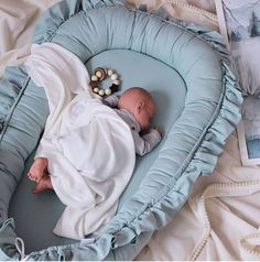 a baby is laying in a blue bassinet