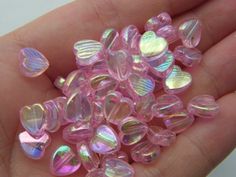 small pink and clear glass hearts in someone's hand