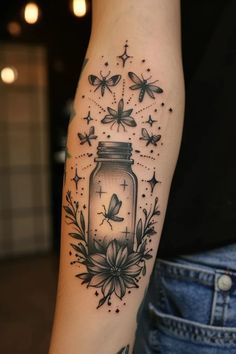 a woman's arm with a jar and butterflies tattoo on the left side of her arm