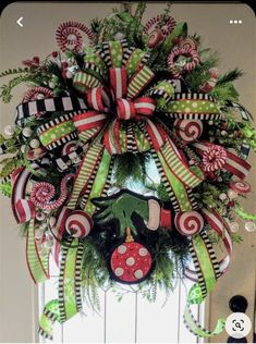 a christmas wreath on the front door with candy canes and a ladybug