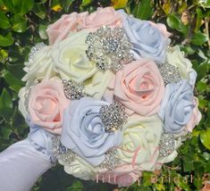 a bridal bouquet with blue, pink and white flowers on it's side